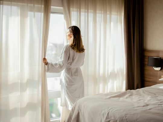 Woman opening her Hotel Curtains