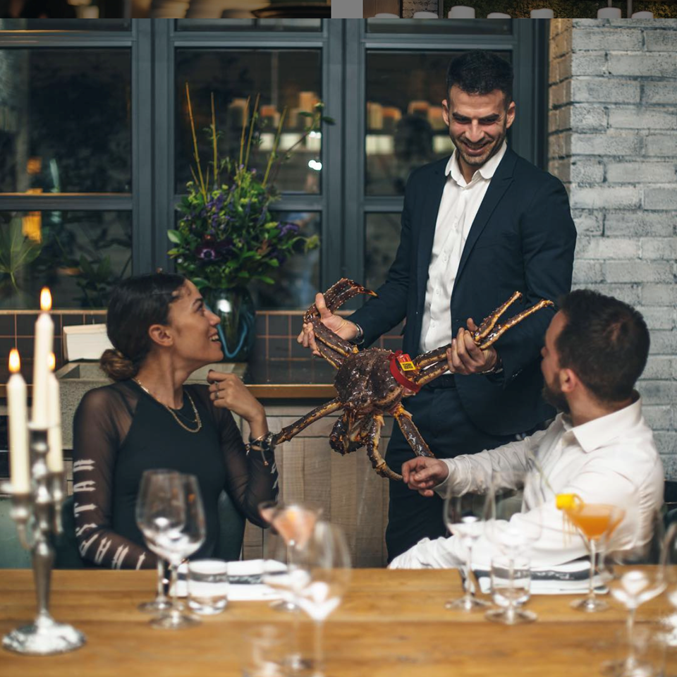 Waiter showing guests crabs